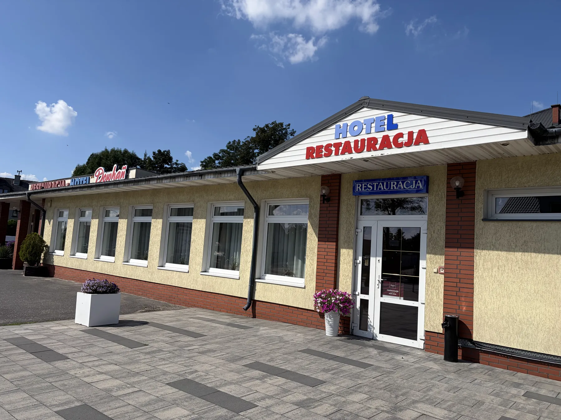 Wejście do restauracji Dowhań i parking przed hotelem
