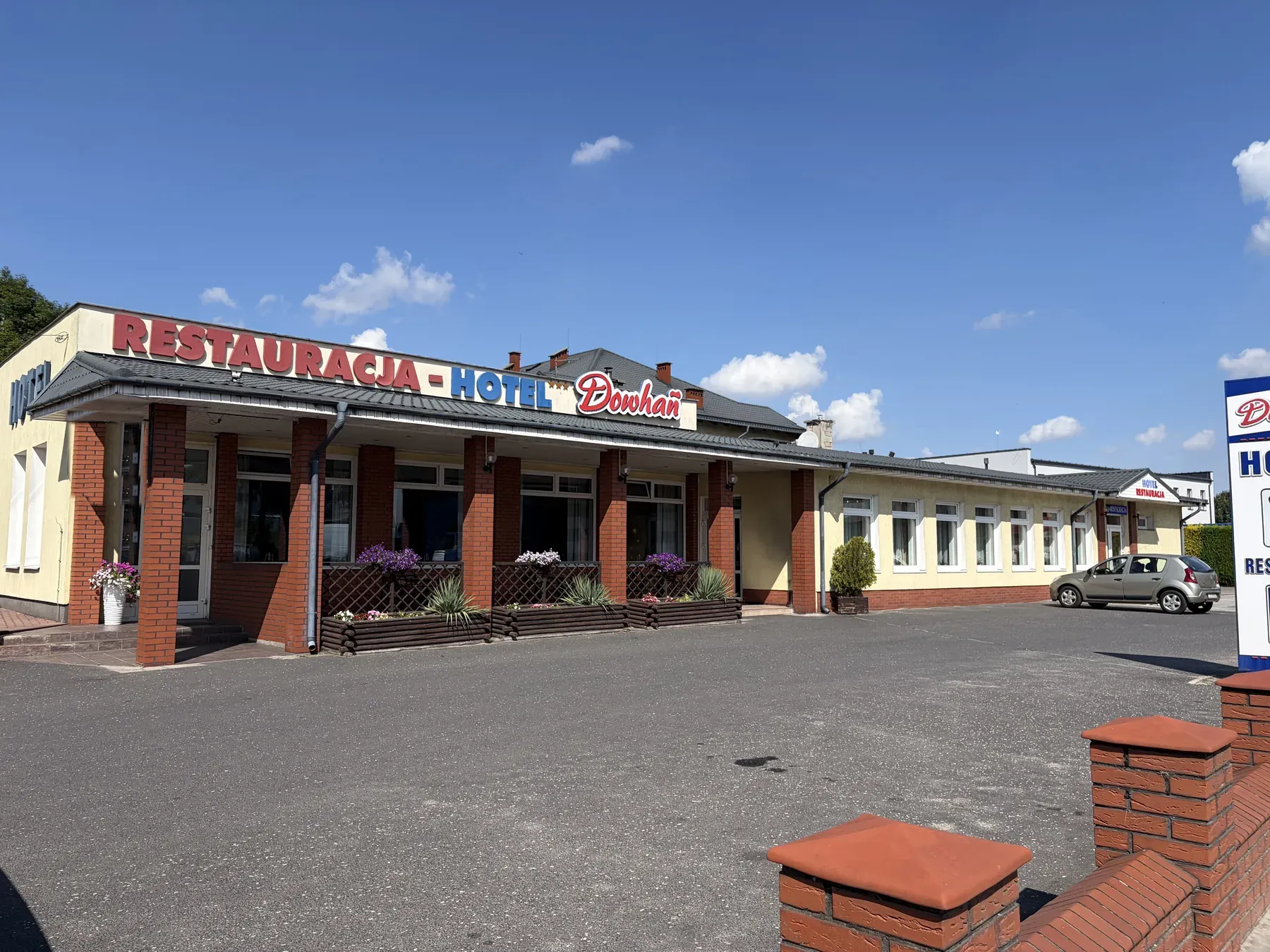 Front restauracji Dowhań z kwiatami przy wejściu